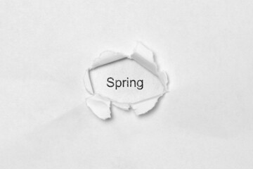 Word Spring on white isolated background, the inscription through the wound hole in paper. Concept of gender identity and sexual minorities. Stock photo for web and print with empty space for text