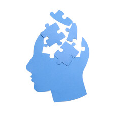 Paper human head and jigsaw puzzle pieces on white background. Concept of dementia