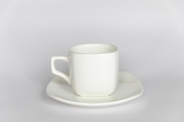Empty white cup on saucer on white background
