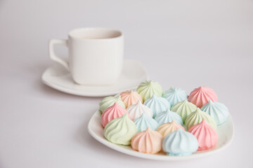 Good morning. meringues and a cup of coffee on a saucer on isolated a white background. Coffee culture concept.