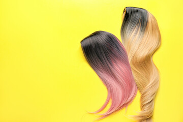 Female wigs on color background