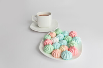 Good morning. meringues and a cup of coffee on a saucer on isolated a white background. Coffee culture concept.