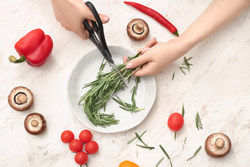 Woman cutting rosemary in kitchen