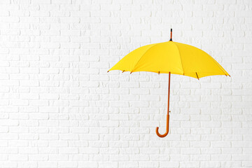Stylish umbrella on white brick background