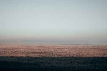Fog over the lake during sunrise. Pink and blue background