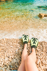 woman legs in flippers at beach sea on background