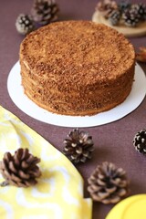 homemade honey cake on brown background with cones 
