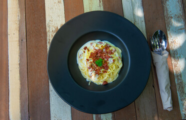 spagetti carbonara on black plate