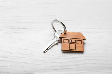 Key from house on white wooden background