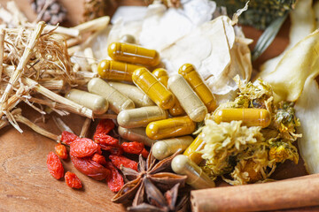 Herbal medicine capsules and dried herb from nature Non-toxic organic product on wooden background...
