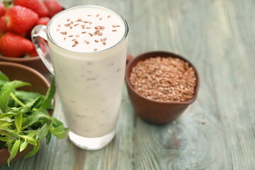 Glass cup of yogurt with flax seeds on wooden background