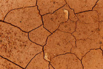 Cracks of the dried soil in arid season / Arid soil , Cracked earth texture of ground broken and rough surface red mud clay
