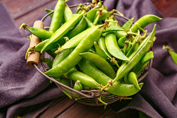 Basket with tasty fresh peas on table