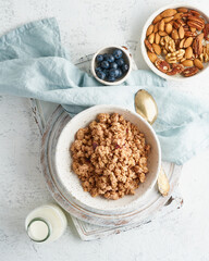 Dry granola in bowl. Breakfast, healthy diet food with milk in bottle, oat flakes
