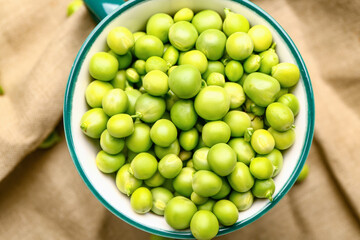 Cup with tasty fresh peas on table, closeup