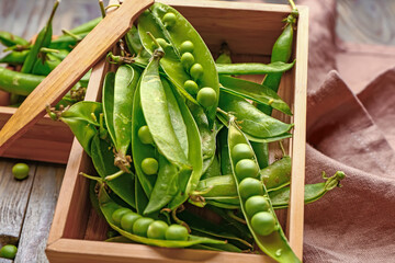 Box with tasty fresh peas on table