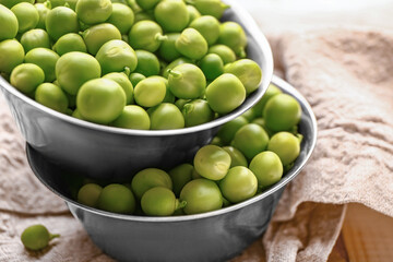 Bowls with tasty fresh peas on table, closeup