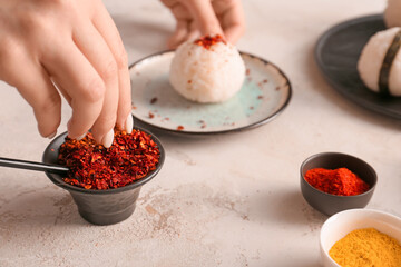 Woman preparing traditional Japanese onigiri on table