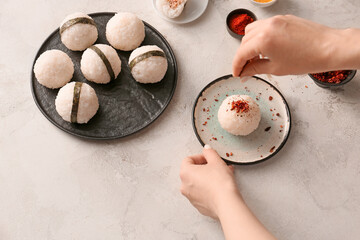 Woman preparing traditional Japanese onigiri on table