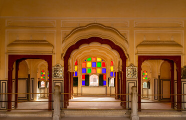Fototapeta na wymiar Jaipur, Rajasthan, India; Feb, 2020 : colourful tinted glass design around windows at the Hawa Mahal, Jaipur, Rajasthan, India