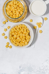 breakfast cereal for children - crispy stars on white table, vertical top view
