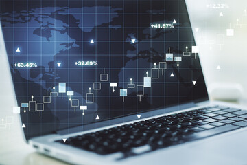 Multi exposure of abstract creative financial graph with world map on modern laptop background, forex and investment concept