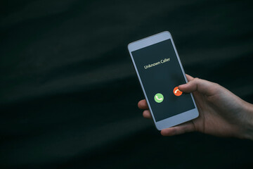 Unknown caller. A girl holds a phone in his hand and thinks to end the call. Incoming from an...