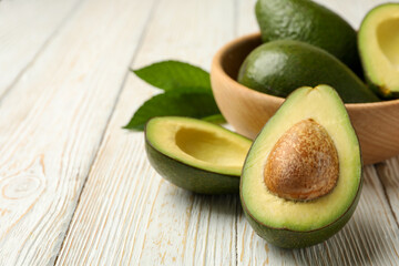 Bowl with fresh avocado on wooden background, close up
