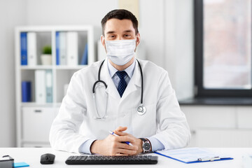 healthcare, medicine and people concept - male doctor in medical mask with stethoscope at hospital