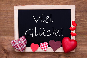 Balckboard With German Text Viel Glueck Means Good Luck. Red Heart Decoration. Brown Wooden Background
