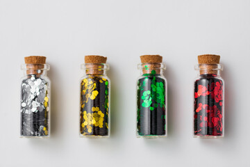 party, decoration and holidays concept - set of different color glitters in small glass bottles...