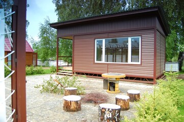 Summer house, bathhouse, green lawn and Christmas trees