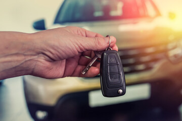 Male hand with car keys with auto on background