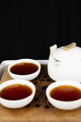 A set of Chinese traditional pottery teapot and cups, serving black tea.