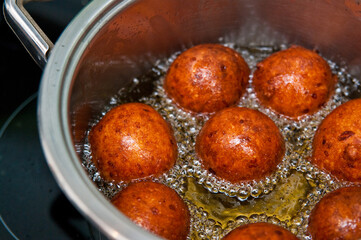 Homemade donuts making boiling in hot oil