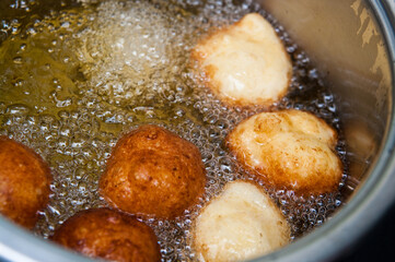 Homemade donuts making boiling in hot oil