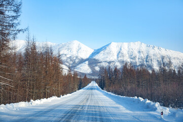 Fototapeta na wymiar Scenic winter landscape of Kolyma Highway (Road of Bones) with amazing Verkhoyansk mountain Range on the background. Adventure travel in Russia from Yakutsk to Magadan