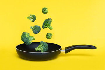 Broccoli in a pan on yellow background. Healthy concept.