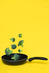 Broccoli in a pan on yellow background. Healthy concept. Copy space