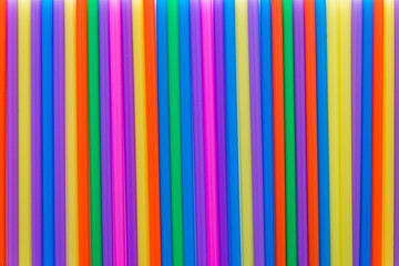 A solid background of many plastic colored straws arranged in row