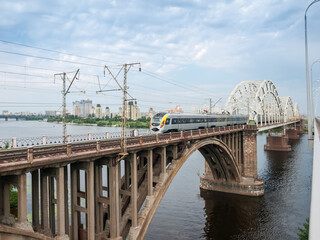 Electric multiple unit on railroad bridge across river, Kyiv, Ukraine