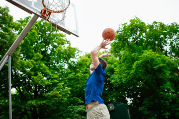 Two young men playing basketball in the park. Friends having a friendly match outdoors	