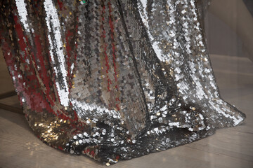 Gorgeous silver train dress of fashion glamour sequins fabric. Shiny Christmas background with copy space
