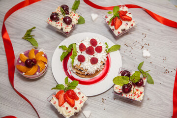 Beautiful desserts with berries: cherries, strawberries, peaches, mint and whipped cream.
