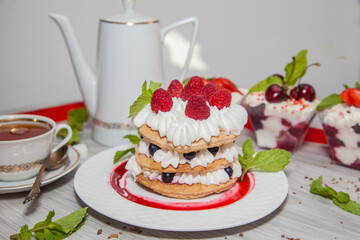 Beautiful desserts with berries: cherries, strawberries, peaches, mint and whipped cream.
