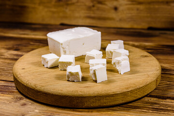 Cutting board with chopped feta cheese on a wooden table