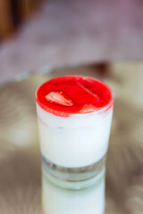 A creamy cocktail with strawberry foam on top, served in a rocks glass