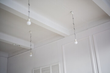 Fototapeta na wymiar Lamps hang directly from the ceiling with laces and cables. Loft style interior