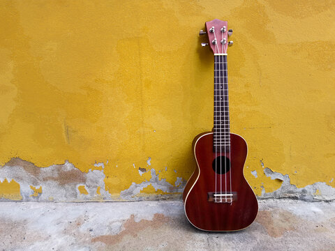 ukulele with yellow background. © phanlakhon