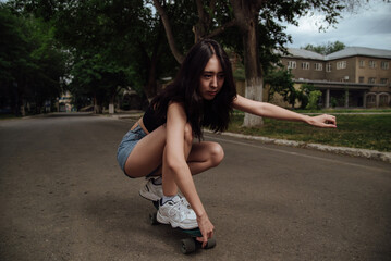 Fototapeta na wymiar Young girl riding a skateboard in the city